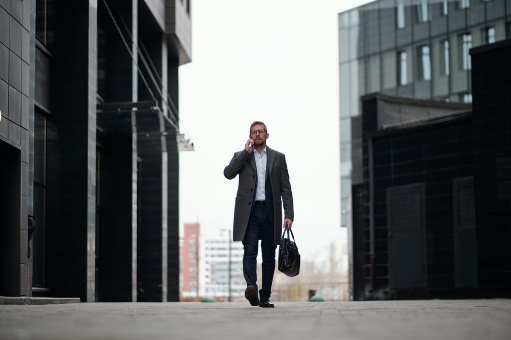 homme en costume qui téléphone en marchant