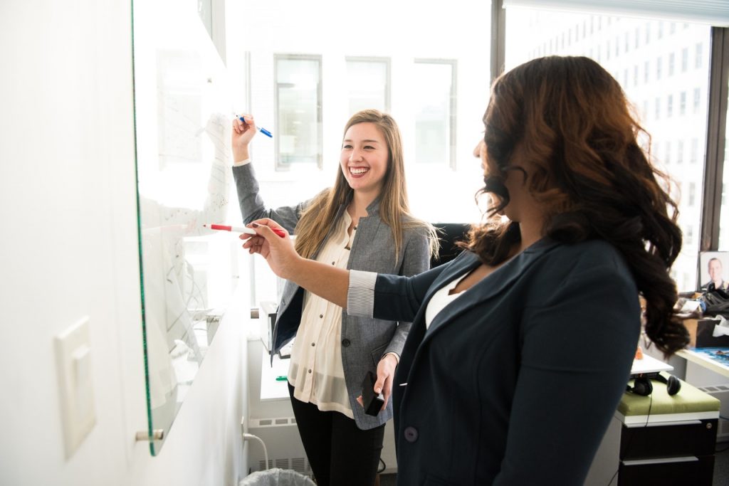 deux femmes qui écrivent sur un tableau